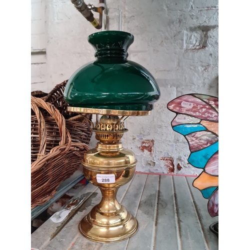 288 - A vintage brass paraffin lamp with funnel and green glass shade.