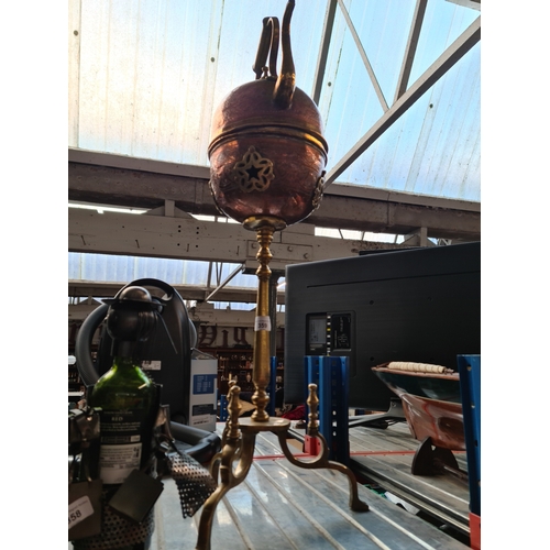 359 - A North African copper kettle mounted on brass tripod stand.