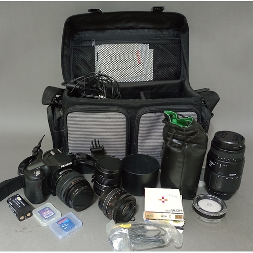 131 - A Pentax IST D camera with lenses and accessories in bag.
