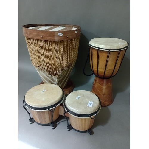 146 - Two African drums and a pair of bongo drums.