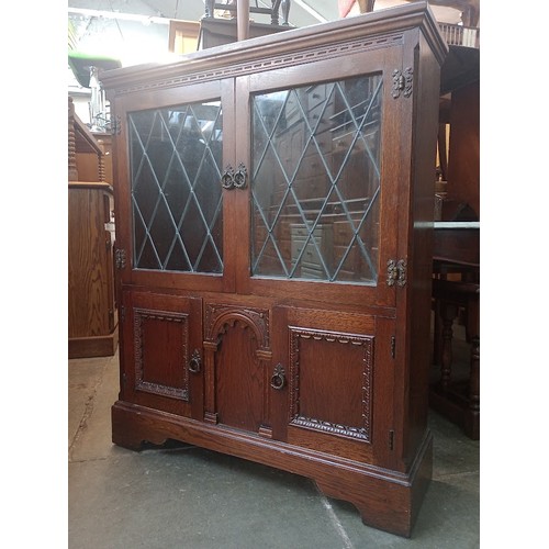 949 - An oak and leaded glass display cabinet and an oak and leaded glass bookcase.