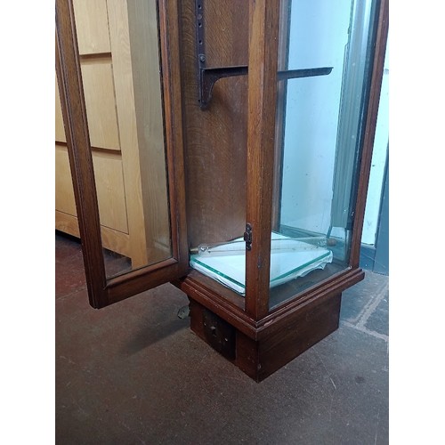 891 - An early 20th century oak and glass elongated shop display cabinet.