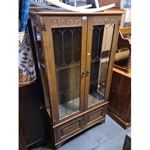 949 - An oak and leaded glass display cabinet and an oak and leaded glass bookcase.