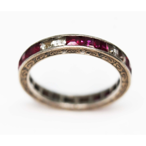 22 - A synthetic ruby and sapphire full eternity ring, engraved outer edge, channel set princess cut ston... 