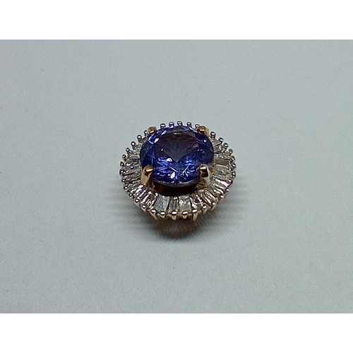 15 - A tanzanite and diamond pendant, marked '9K', gross weight 0.95 grams.