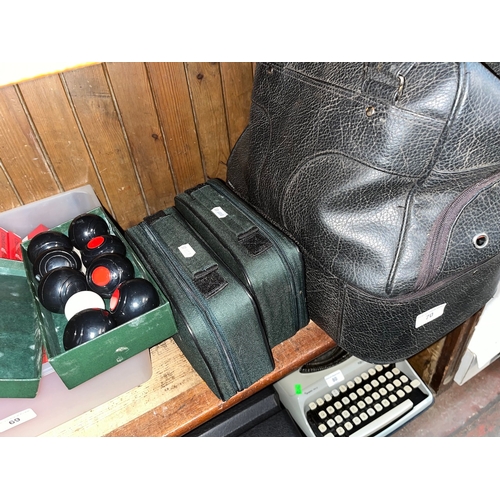 70 - A leather bag containing various crown green bowls together with two sets of Boules and a set of min... 