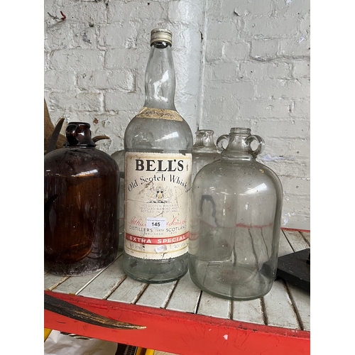 145 - 4 demijohns and a 1 gallon Bell's whisky bottle.