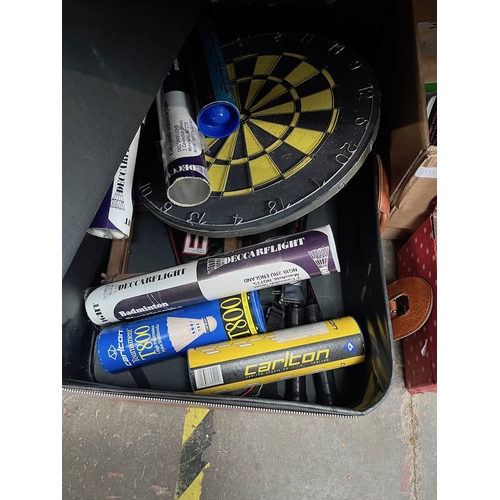 312 - A box of sporting equipment including darts and boards, badminton racquets and shuttles etx