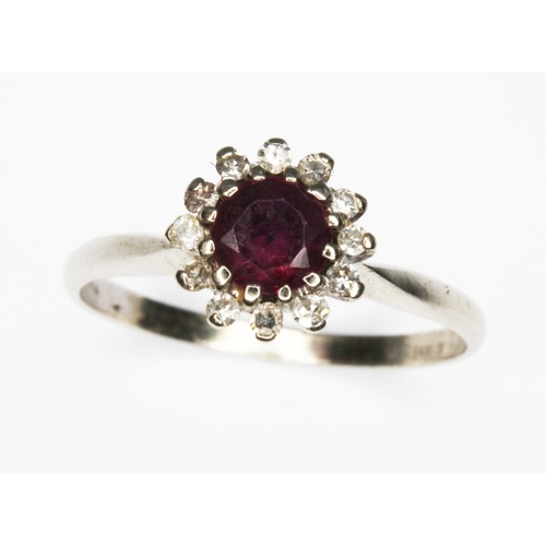 61 - A diamond and ruby cluster ring, the cluster measuring approx. 8mm in diameter, 18ct import marks, g... 