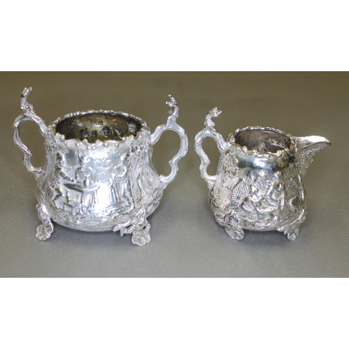 151 - A Victorian matched four piece silver tea set, decorated all over with in repousse depicting joyful ... 