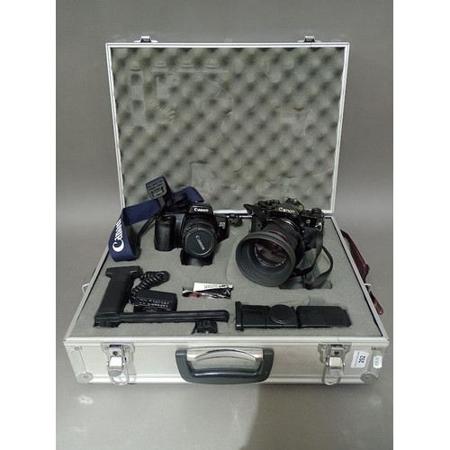 292 - A Canon EOS 1000F and a Canon A1 camera with accessories in hard case.