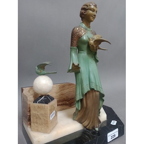 229 - An Art Deco cold painted spelter figure of a lady holding a dove on marble base.