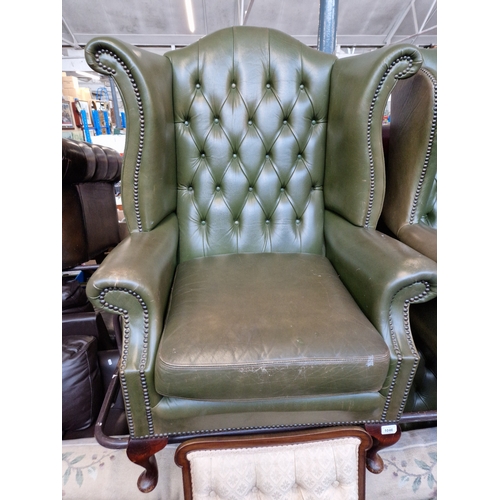 1046 - A green leather Chesterfield wingback armchair. The upholstery may not comply with the Furniture and... 