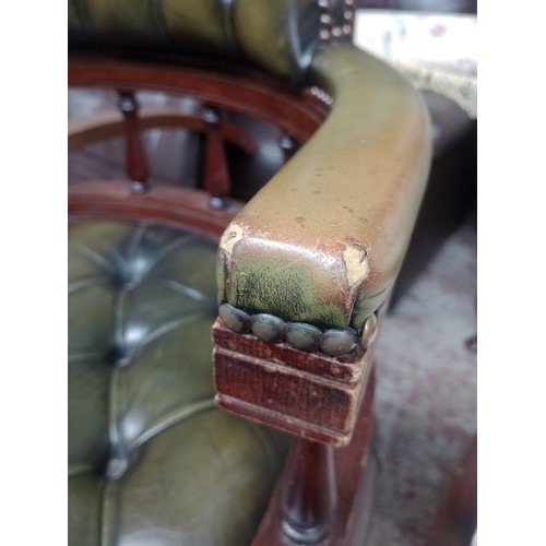 1047 - A green leather Chesterfield captain's chair.