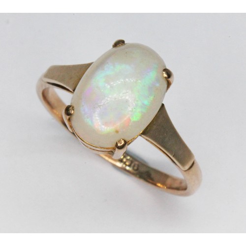 65 - An opal ring, the oval flat bottom opal cabochon measuring approx. 10mm x 7mm x 4mm, marked '9ct', g... 