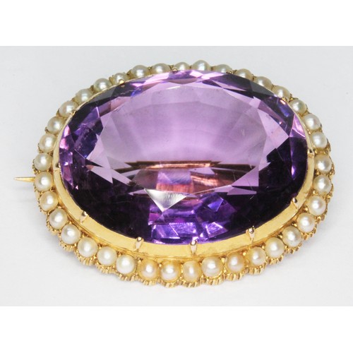 89 - An antique amethyst and seed pearl brooch, the bezel set oval mixed cut amethyst weighing approx 33c... 