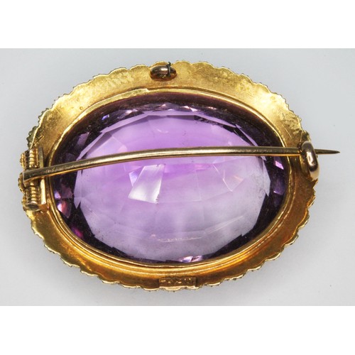 89 - An antique amethyst and seed pearl brooch, the bezel set oval mixed cut amethyst weighing approx 33c... 