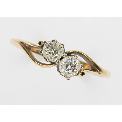 99 - A diamond cross over ring, the two round cut diamonds weighing approx. 0.32cts in total, band unmark... 