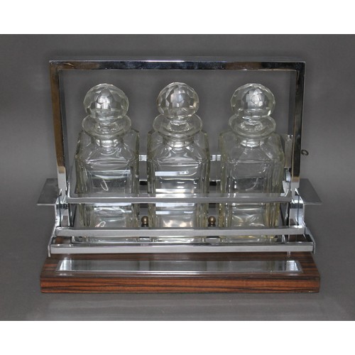 125 - A French Modernist tantalus attributed to Jacques Adnet (1900-1984), circa 1960, three glass decante... 