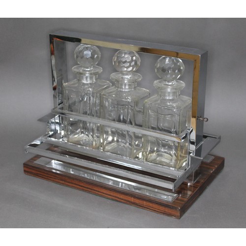 125 - A French Modernist tantalus attributed to Jacques Adnet (1900-1984), circa 1960, three glass decante... 