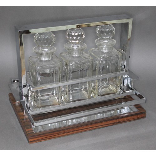 125 - A French Modernist tantalus attributed to Jacques Adnet (1900-1984), circa 1960, three glass decante... 