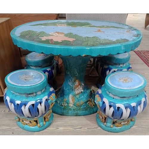 194 - A Chinese ceramic garden table and four stools, the table having landscape scene to top with dragon ... 