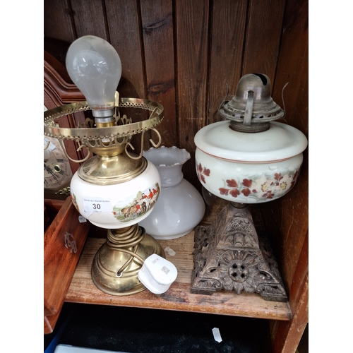 30 - An oil lamp with cast base, glass bowl and funnel, and a brass electric table lamp in the form of an... 