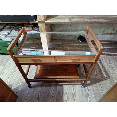 1067 - A mid 20th century teak trolley with mirrored top.