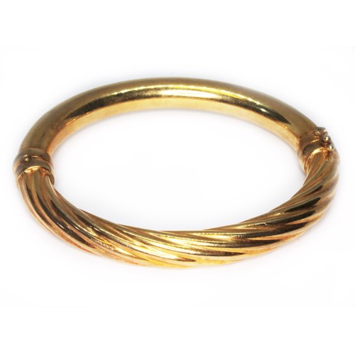 3 - An Italian twist bangle, marked '375', diam. 5.5mm, wt. 16.6g.