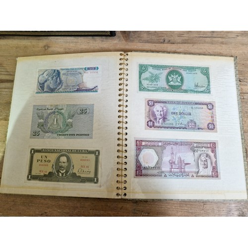 243 - Three folders of assorted world banknotes