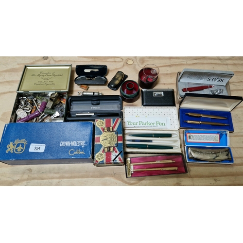 324 - A box of collectables including Paper Mate pens, Parker pens, Royal memorabilia including tin money ... 