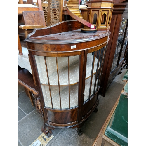 960 - A mahogany demi-lune display cabinet standing on ball and claw feet.