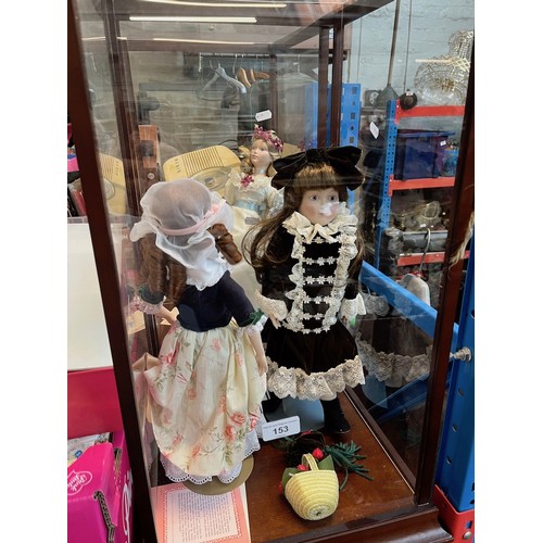 153 - Two perspex display cases with 3 dolls.