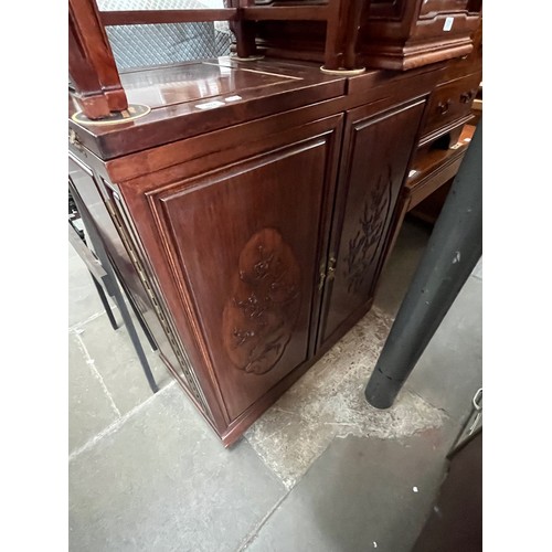 924 - A Chinese carved hardwood fold out cocktail cabinet.