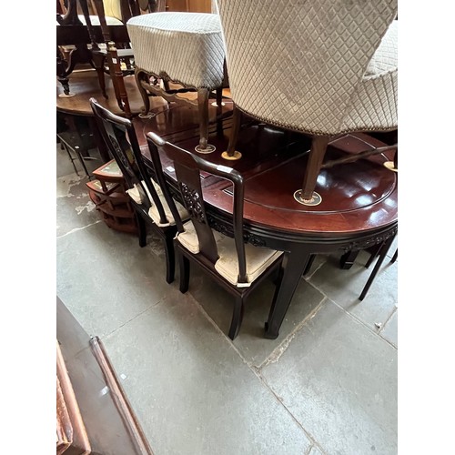 922 - A Chinese carved hardwood extending dining table and four chairs.