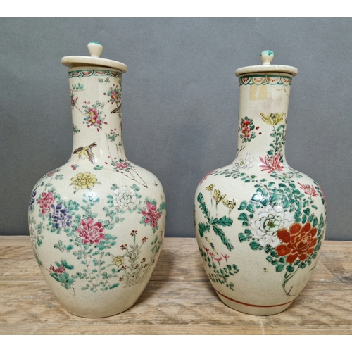 598 - A pair of Japanese crackled and hand painted vases with lids.