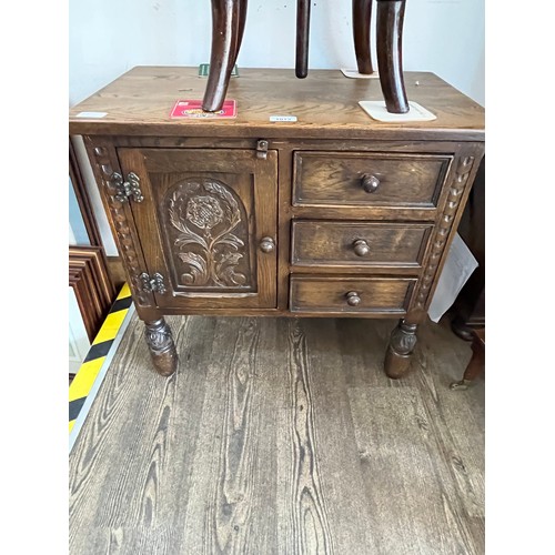 1013 - A carved oak cabinet with three drawers.