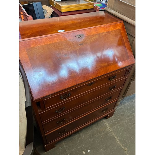 1006 - A yew wood bureau, standing on bracket feet.