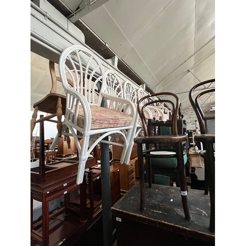 1008 - A set of four white painted cane chairs.