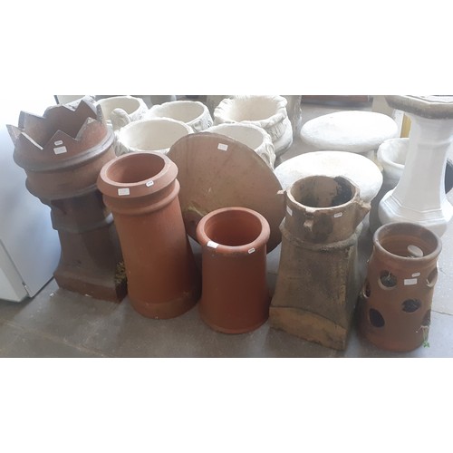 219 - Four chimney pots, a terracotta strawberry planter and a stoneware fire pit/planter.