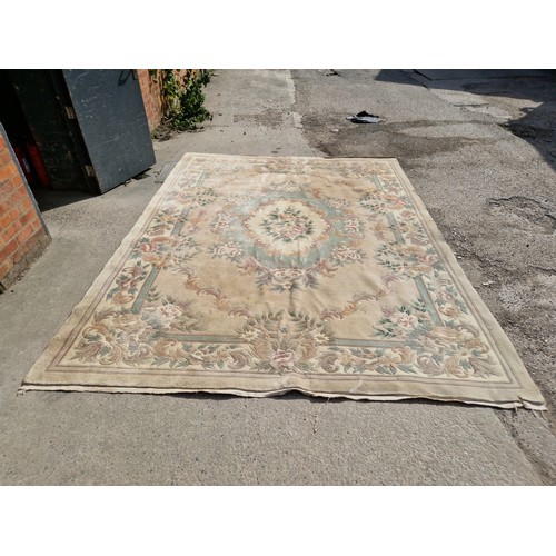 991 - A large Chinese wool carpet, cream ground decorated with flowers.