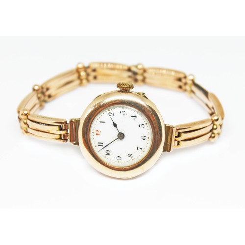 57 - A late Victorian/Edwardian ladies 9ct gold watch and strap, white enamel dial with gold dot minute m... 