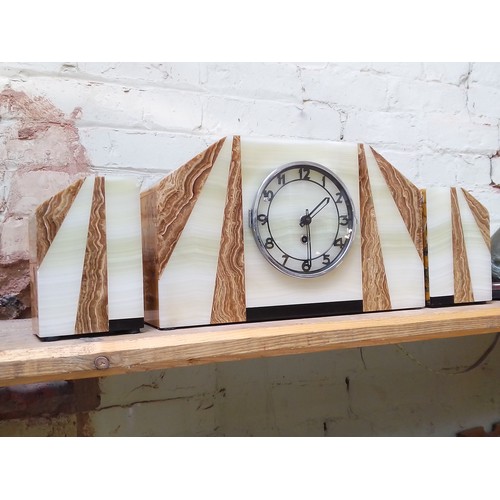 175 - An Art Deco marble mantle clock with garnitures.