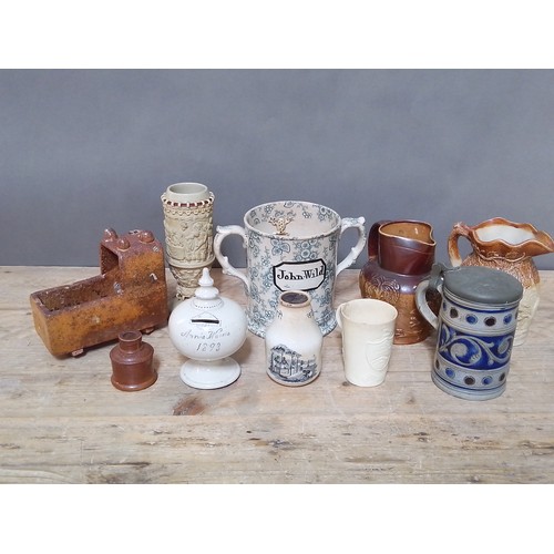 145 - Assorted ceramics including a salt glazed crib, relief moulded pottery, a named loving mug 'John Wil... 