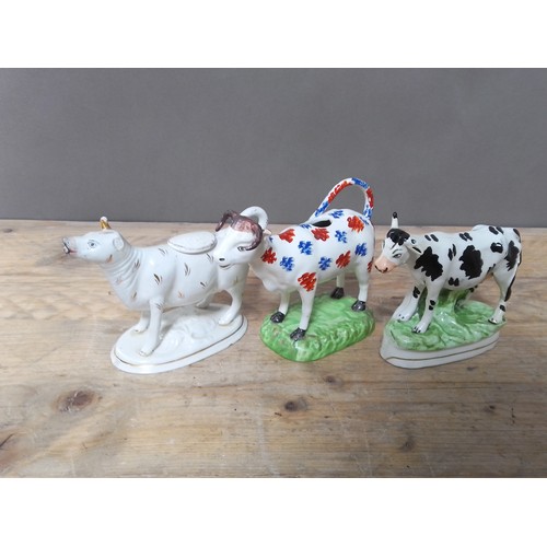 184 - A box of assorted Staffordshire pottery cow figures.