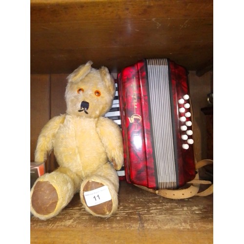 11 - A vintage musical teddy bear and a child's piano accordion.