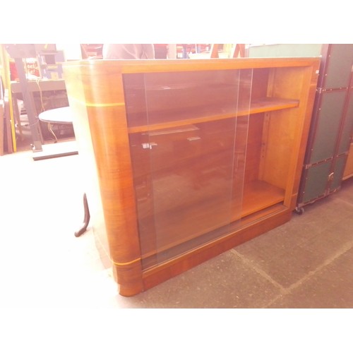 784 - An Art Deco walnut bookcase with sliding glass doors.