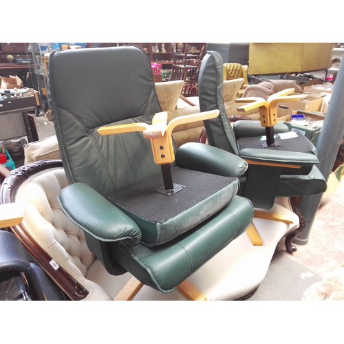 770 - A pair of green faux leather swivel chairs with stools.