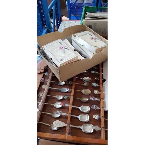 200 - A collection of collector's spoons on racks together with boxed cutlery.