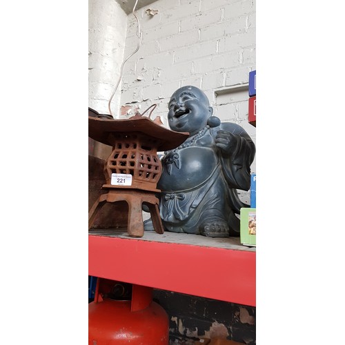 221 - An Eastern cast iron candle holder and a Buddha.